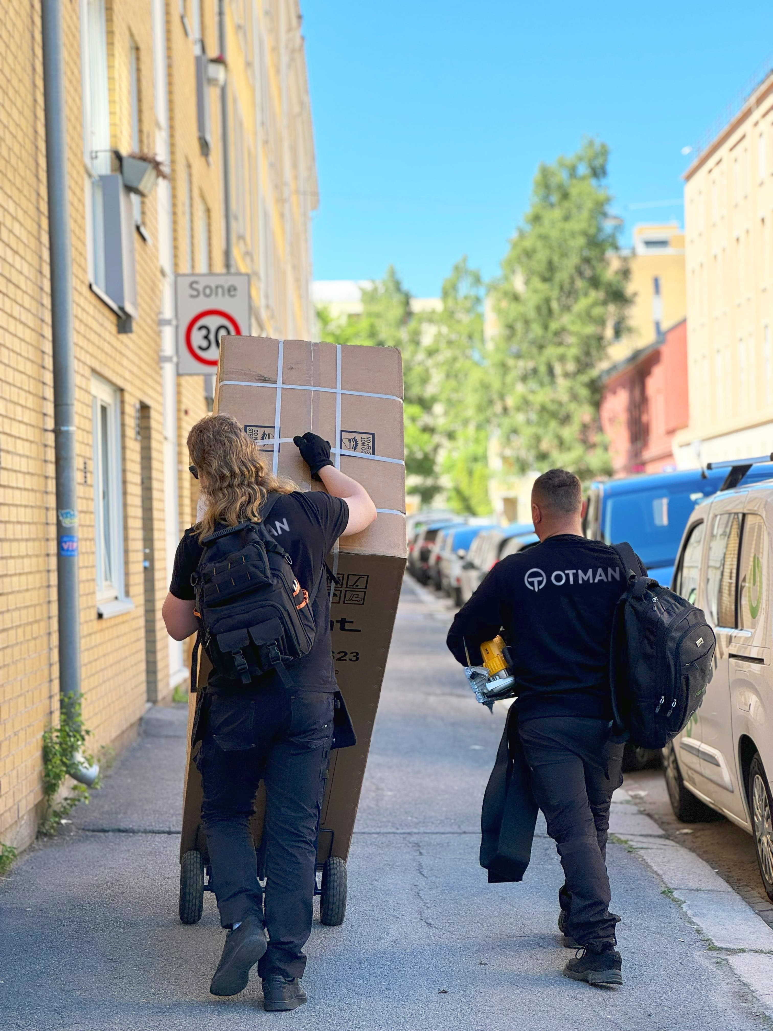 Otman Transport-team som bærer en leveranse